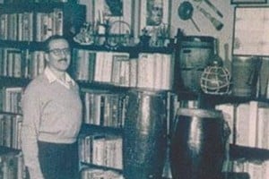 Ortiz Oderigo en su casa con su colección de libros y objetos de origen africano.