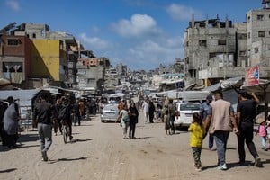 Mientras Hamás demora su respuesta, gazatíes caminan junto a edificios destruidos en Jan Yunis. EFE/DW
