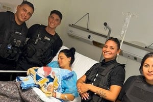 Los policías sonrientes junto a la feliz madre y su bebé.Foto: Gentileza