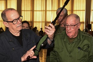 Imagen que refleja el momento en el que Silvio Rodríguez recibe su fusil de parte de un oficial del ejército cubano, en presencia del presidente Miguel Díaz-Canel (semitapado).