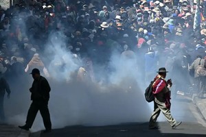 Manifestantes huyen de los gases lacrimógenos durante enfrentamientos con la policía antidisturbios en La Paz, 18 de mayo de 2026.
