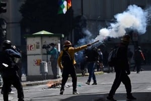 Un manifestante lanza un petardo durante una marcha que exige la renuncia del presidente de Bolivia, Rodrigo Paz