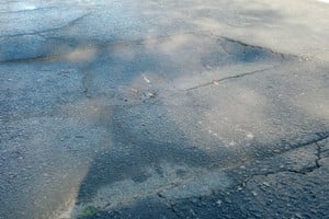 Denuncian profundos baches en calle Urquiza y piden arreglos urgentes.