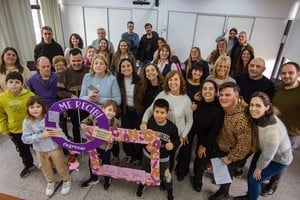 Delia Gelín (de celeste, en el centro) logró recibirse de Licenciada en Comunicación a sus 75 años. Hijos, nietos y la comunidad universitaria en su día de presentación de tesis. Foto: Gentileza
