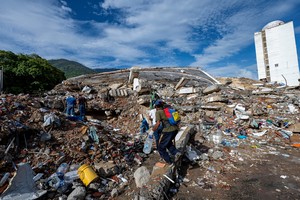 Voluntarios caminan entre los escombros de un edificio derrumbado en Caraballeda. MIGUEL MEDINA / REUTERS