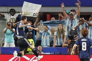El salto del festejo, al estilo Maradona, de Lionel Messi luego de su gol ante Jordania. Atrás, un cartel que lo dice todo.