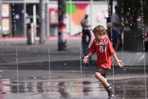 Un niño se refresca en una en un área de juegos acuáticos durante una ola de calor, en Viena, Austria. Xinhua/He Canling