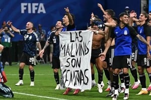 Parte del plantel argentino muestra orgtulloso la bandera con la leyenda sobre las Islas Malvinas tras el triunfo ante Inglaterra.