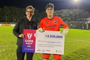 Francisco Sciarini recibió el cheque de manos de Daniel Di Lena, de Lotería de Santa Fe. Foto: Pablo Busso.