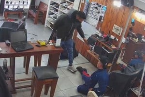 El momento en que el delincuente reduce al peluquero. Foto: captura video